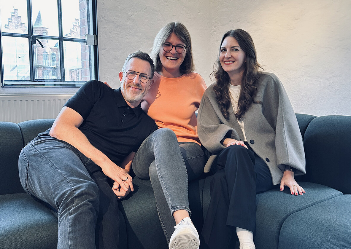 3 Personen auf dem Sofa sitzend